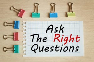 Bulldog clips with writing on paper that reads 'ask the right questions'
