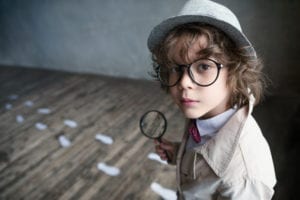 Young boy in with magnifying glass